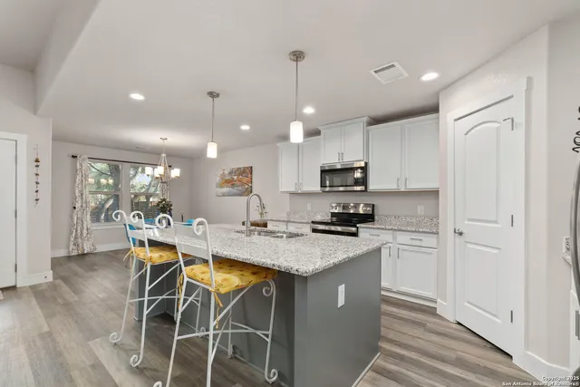 a kitchen with stainless steel appliances kitchen island granite countertop a sink and cabinets