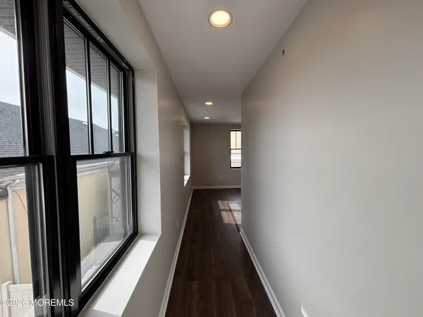 a view of a hallway with wooden floor and staircase