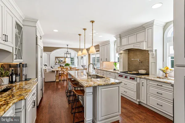 a kitchen with stainless steel appliances granite countertop a stove a sink and a wooden floors