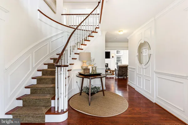a living room with wooden floor and a dining table