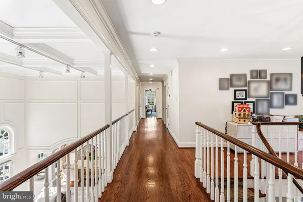 a view of a hallway with wooden floor and staircase