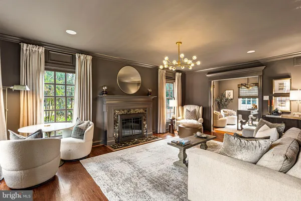 a living room with furniture a fireplace and a large mirror