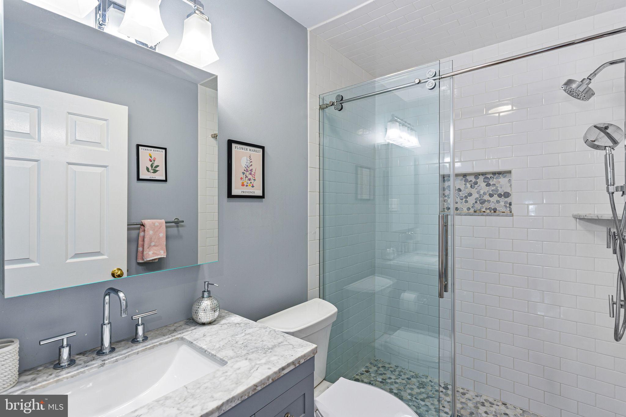 380 Kings Highway West Haddonfield, NJ 08033 - Photo 45 of 50 a bathroom with a granite countertop sink toilet a mirror and shower