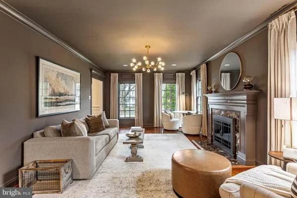 a living room with furniture a fireplace and a chandelier
