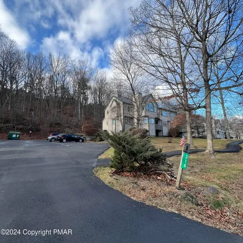 a view of a park that has a tree on the side of the road