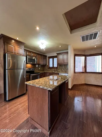 a kitchen with stainless steel appliances granite countertop a stove a sink and a refrigerator