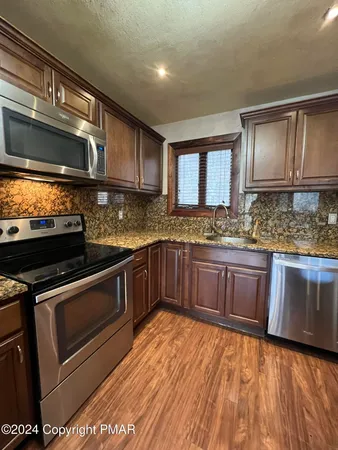 a kitchen with kitchen island a stove a refrigerator and a sink
