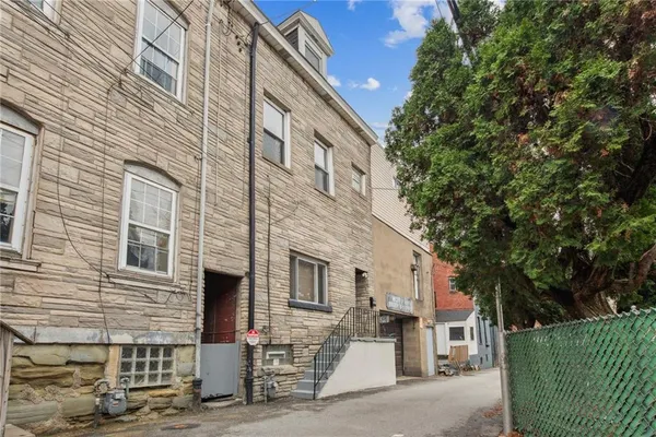a front view of a building with a garden