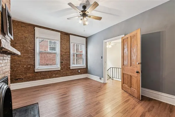 a view of an empty room with wooden floor and a fireplace