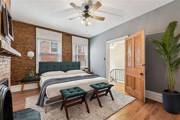 an empty room with wooden floor fan and windows