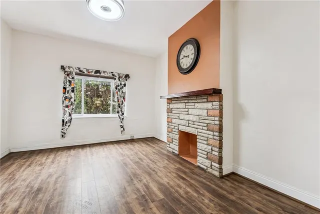 an empty room with wooden floor and a window