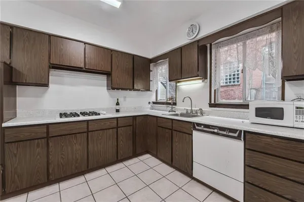 a kitchen with stainless steel appliances granite countertop a refrigerator a sink dishwasher a stove with wooden cabinets