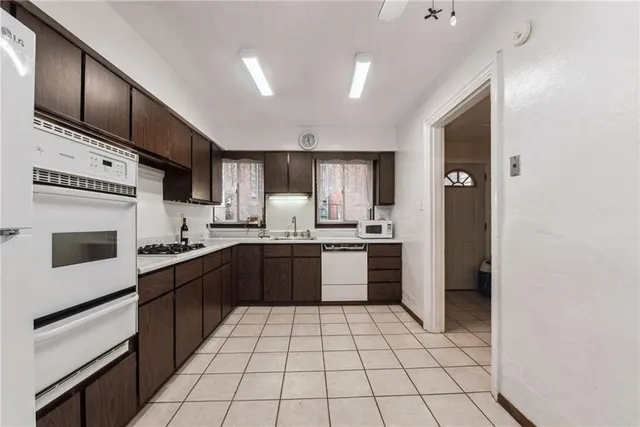 a kitchen with stainless steel appliances a table chairs and a refrigerator