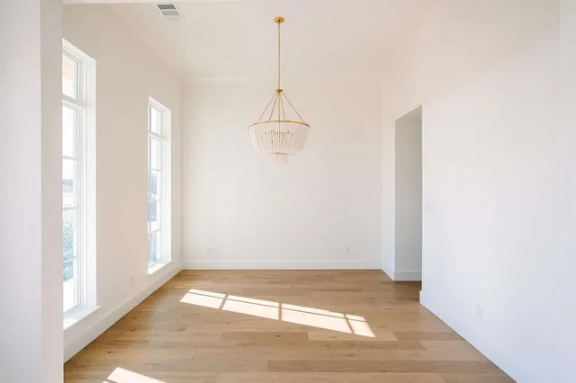 a view of a room with a window and wooden floor