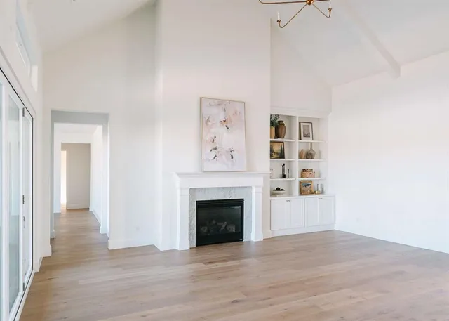 a view of a livingroom with wooden floor and a fireplace