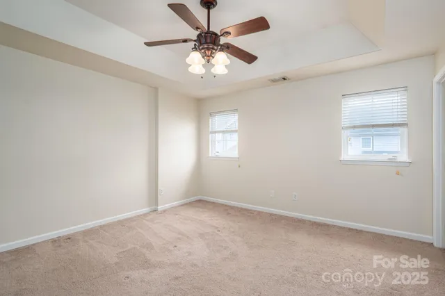 an empty room with a window and a fan