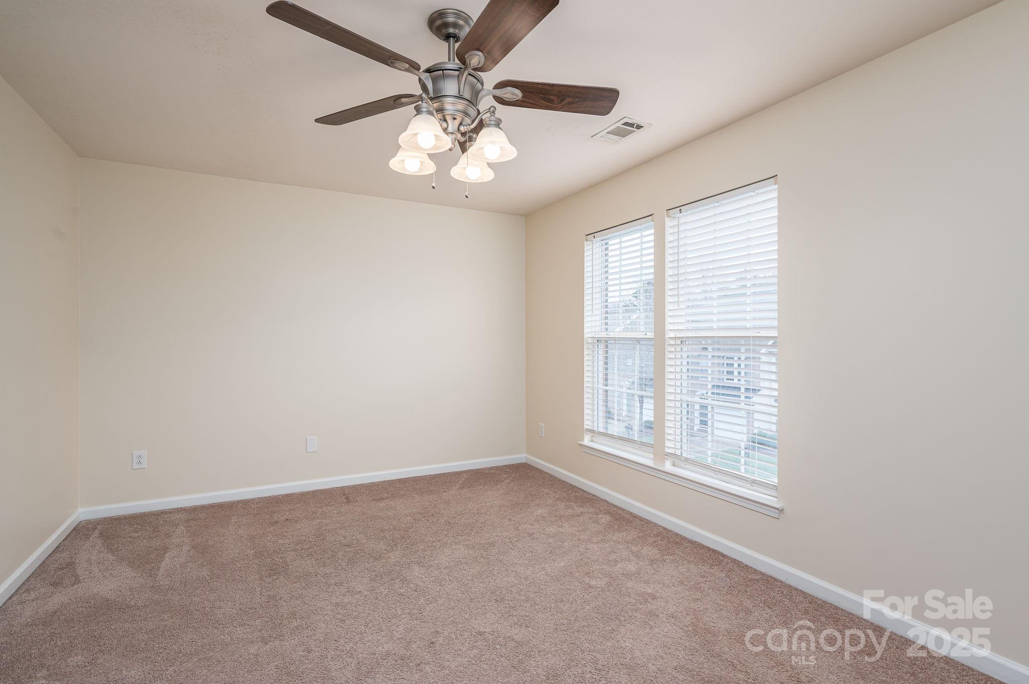7937 Mariners Pointe Circle Denver, NC 28037 - Photo 24 of 38 an empty room with a chandelier fan and windows
