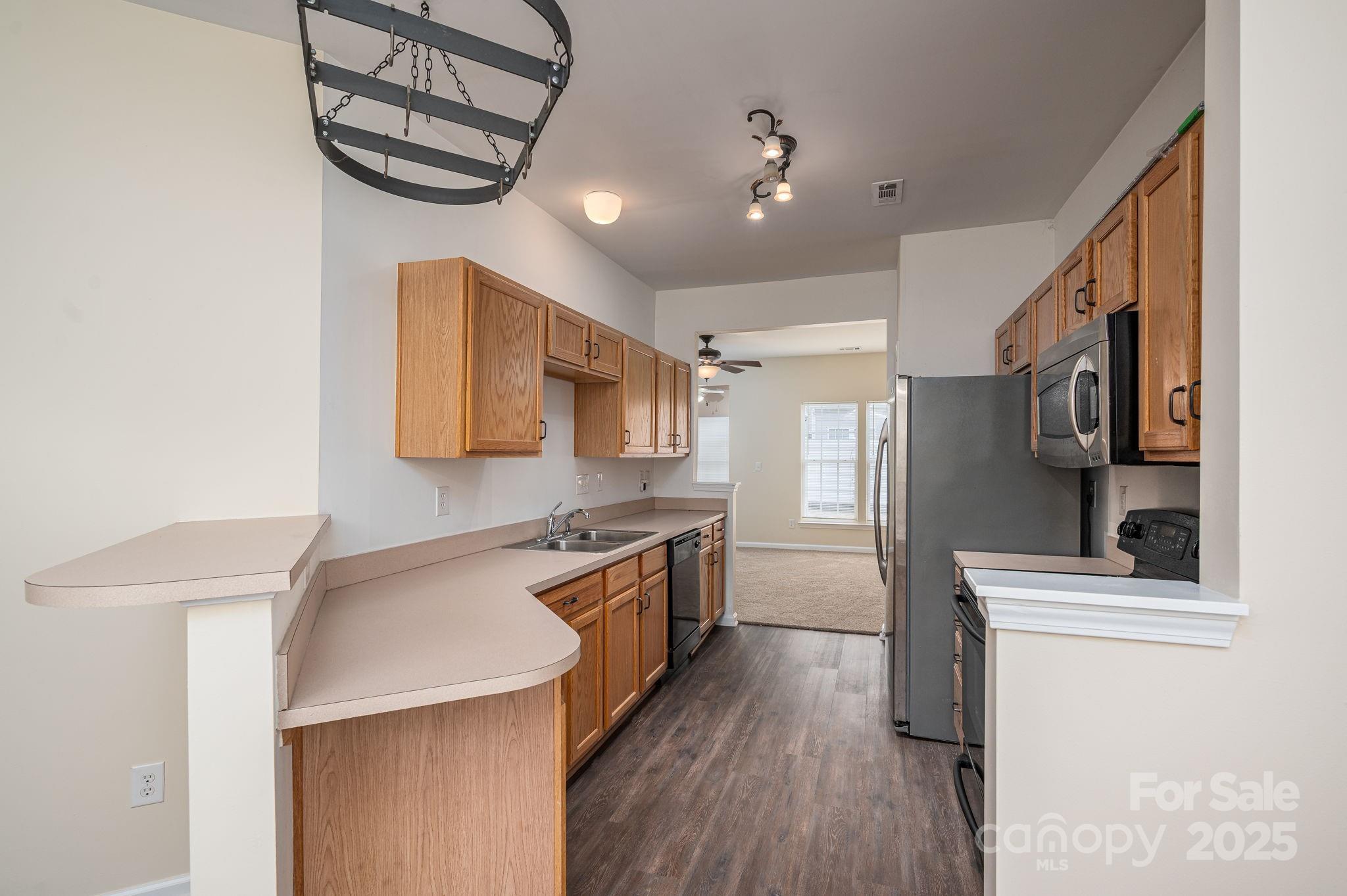 7937 Mariners Pointe Circle Denver, NC 28037 - Photo 6 of 38 a kitchen with stainless steel appliances a sink cabinets and wooden floor