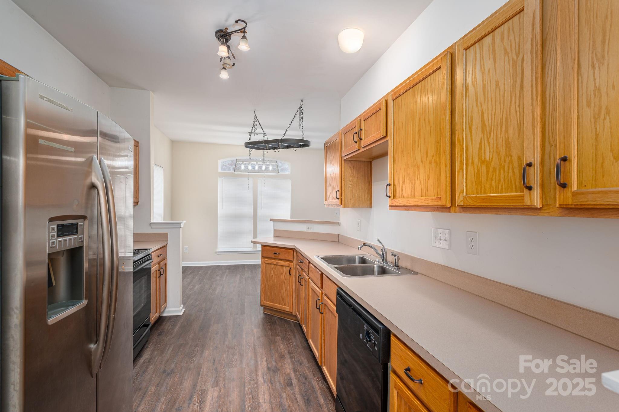 7937 Mariners Pointe Circle Denver, NC 28037 - Photo 8 of 38 a kitchen with stainless steel appliances granite countertop a sink a stove a refrigerator cabinets and wooden floor