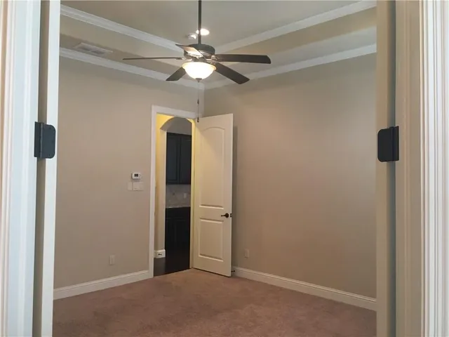 an empty room with closet and a chandelier fan