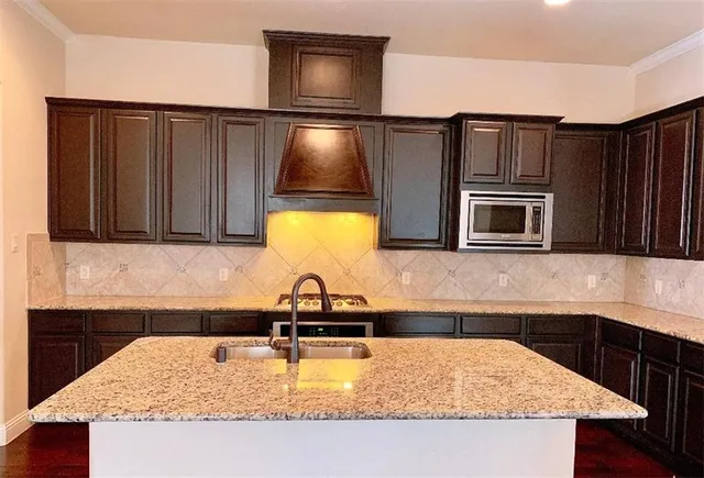 a kitchen with kitchen island a sink and wooden cabinets