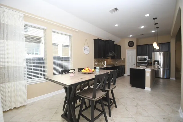 a large kitchen with a counter space appliances and a ceiling fan