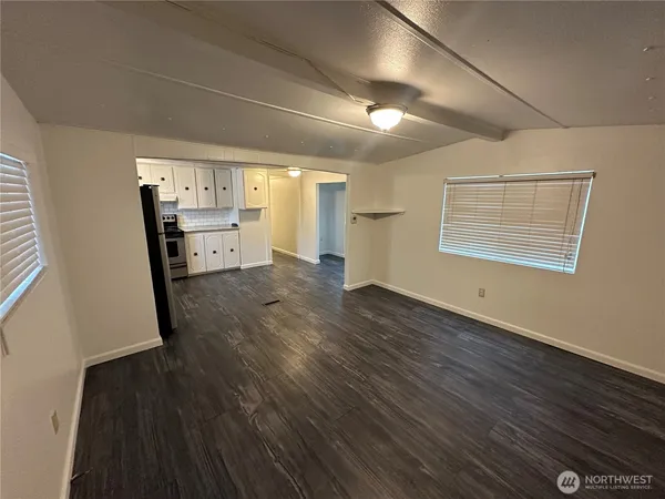 a view of empty room with wooden floor