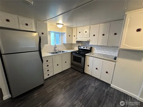 a kitchen with granite countertop white cabinets and white appliances