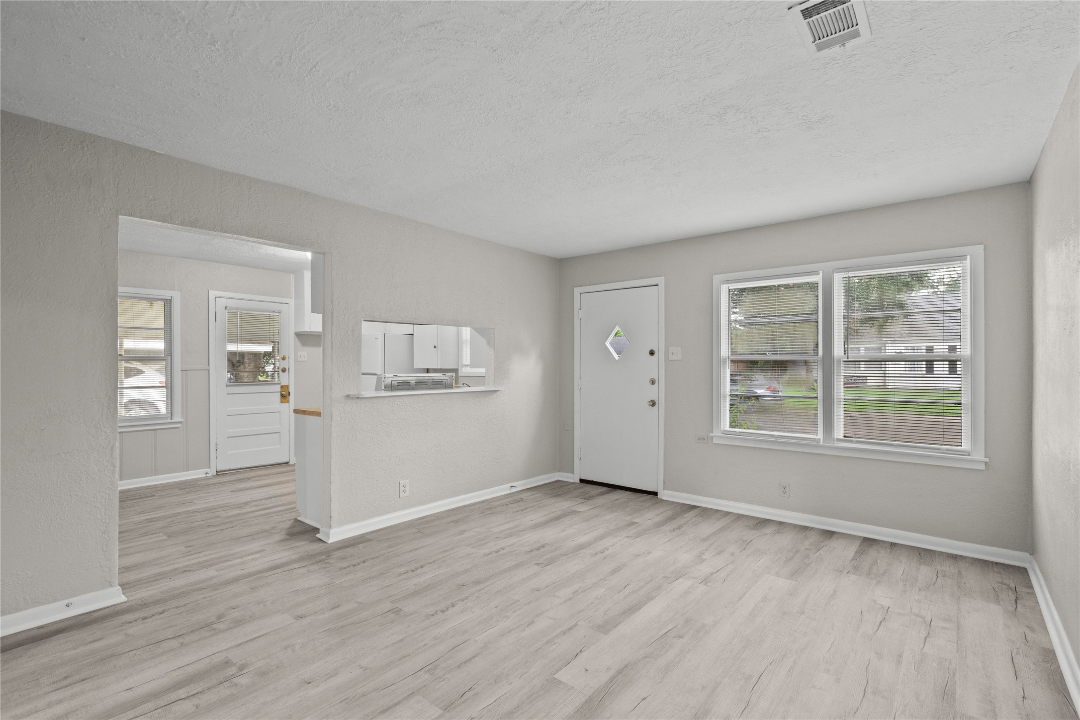 411 Forrest Street Baytown, TX 77520 - Photo 2 of 9 an empty room with wooden floor and windows