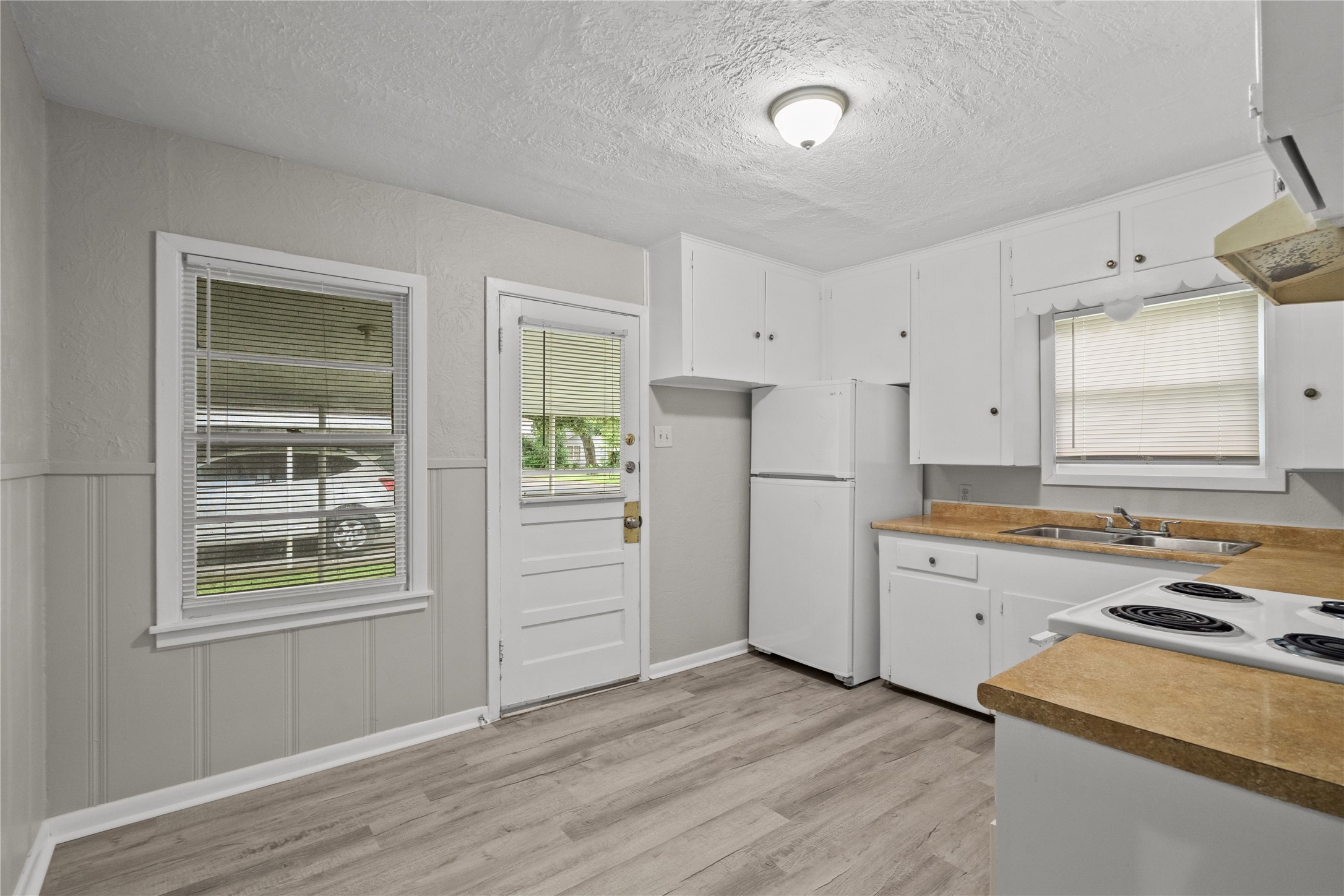 411 Forrest Street Baytown, TX 77520 - Photo 3 of 9 a kitchen with a refrigerator and a stove top oven