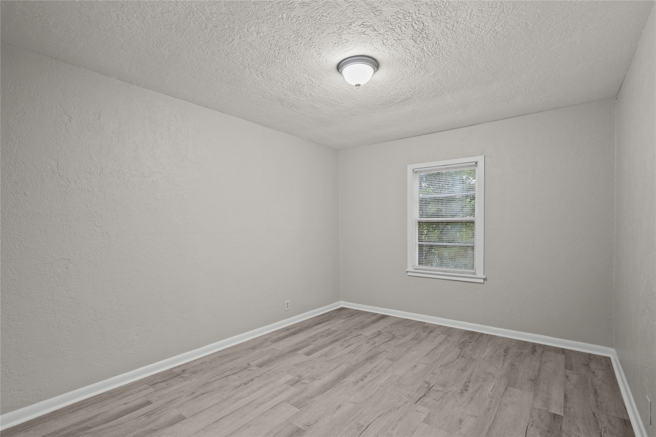 411 Forrest Street Baytown, TX 77520 - Photo 5 of 9 an empty room with wooden floor and windows
