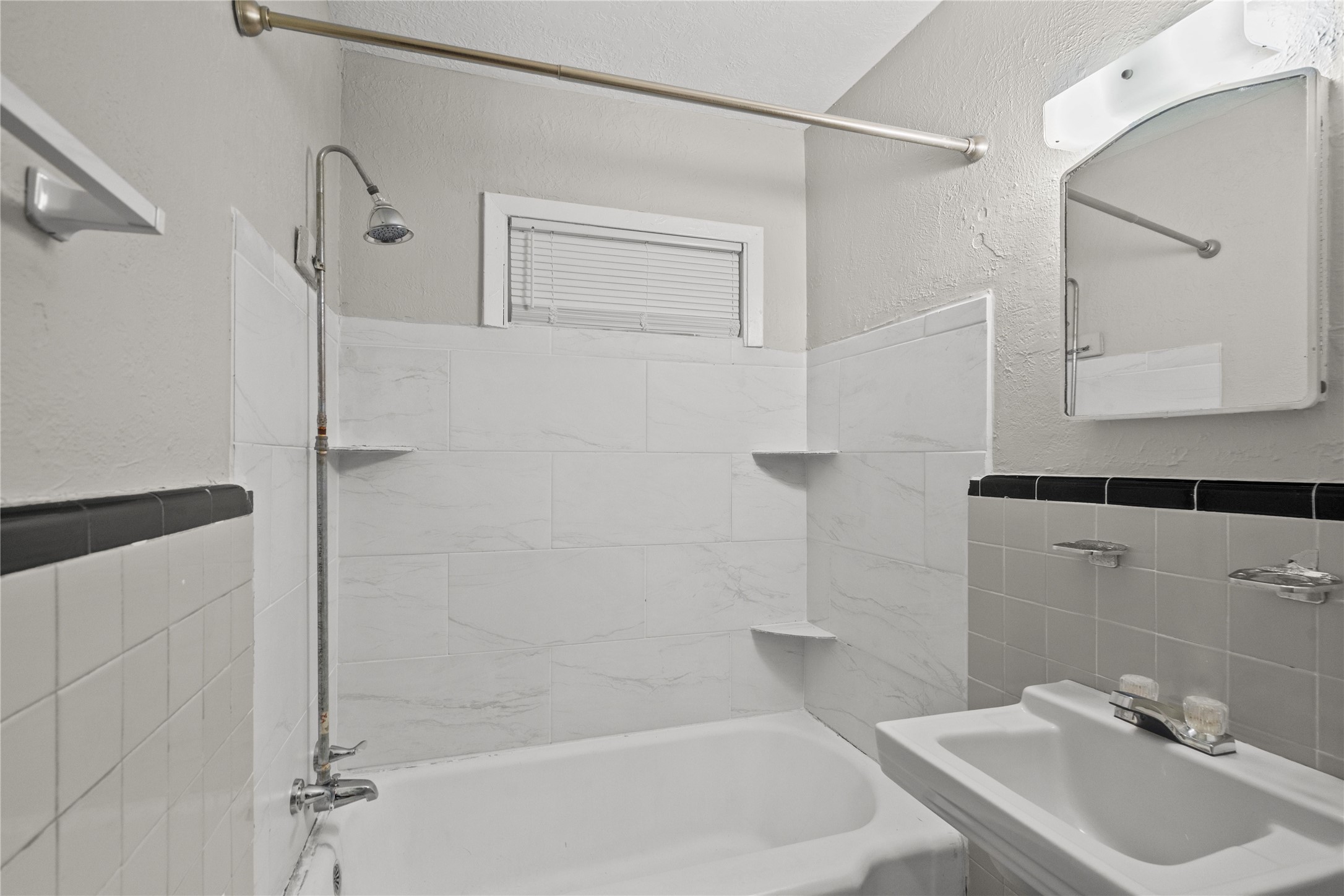 411 Forrest Street Baytown, TX 77520 - Photo 6 of 9 a bathroom with a sink a mirror and a shower