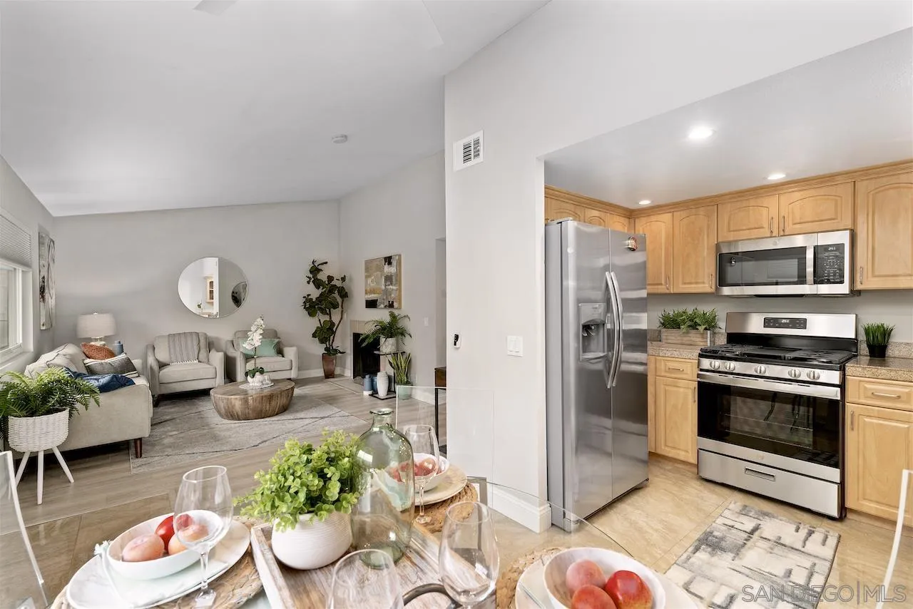 a kitchen with stainless steel appliances kitchen island granite countertop a stove a refrigerator and a dining table