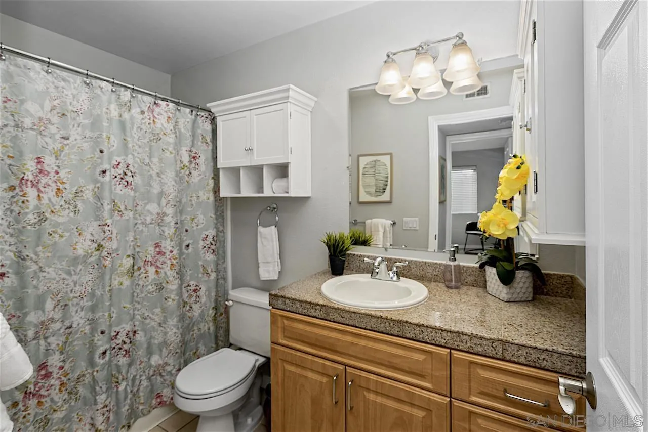 4375 37th Street, Unit 8 San Diego, CA 92105 - Photo 13 of 17 a bathroom with a granite countertop sink a toilet and a mirror