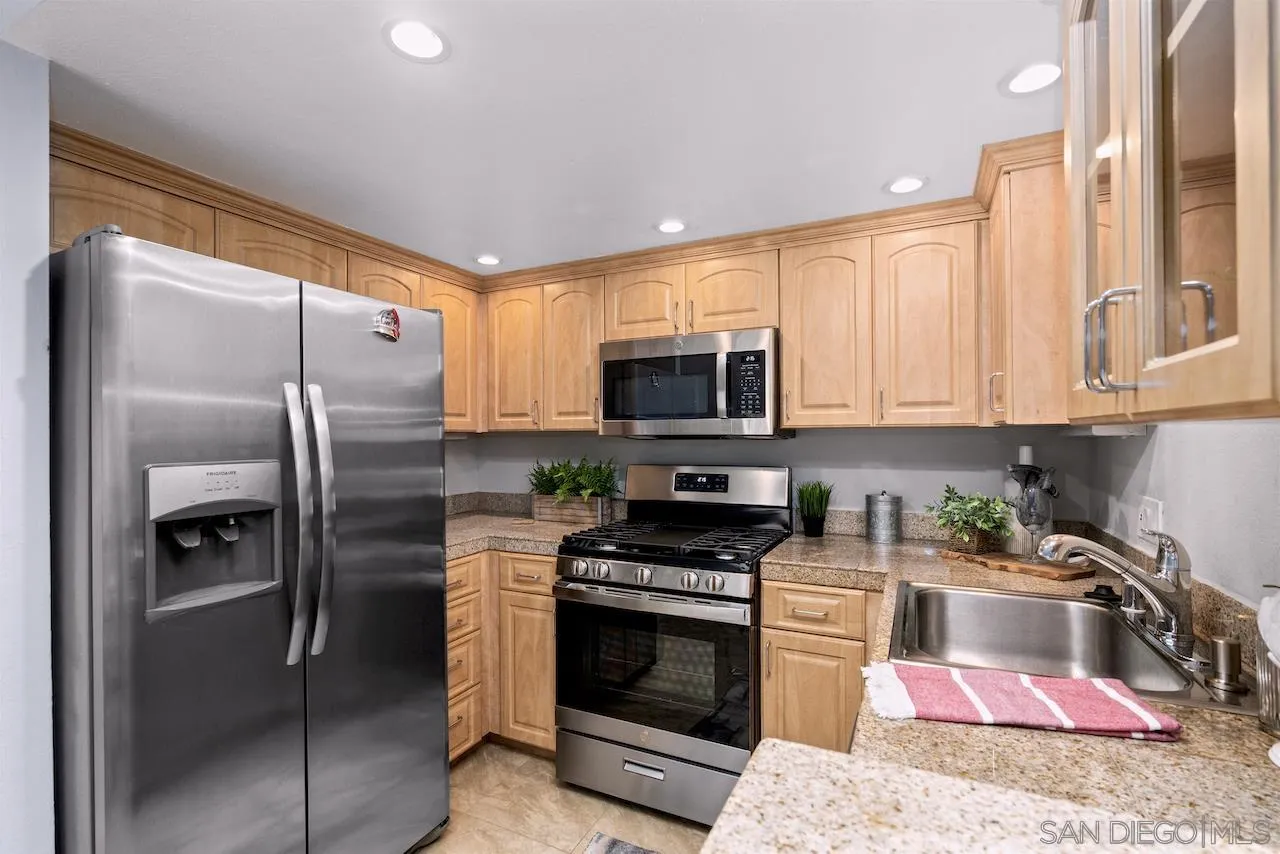 4375 37th Street, Unit 8 San Diego, CA 92105 - Photo 7 of 17 a kitchen with stainless steel appliances granite countertop a refrigerator a stove and a sink with wooden floor