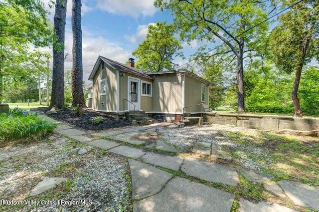 a front view of house with yard and trees around
