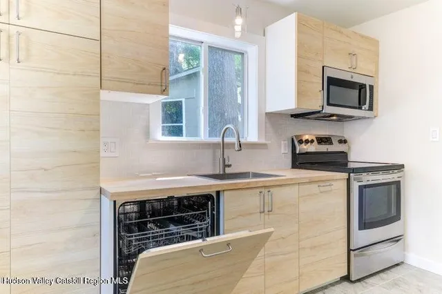 a kitchen with stainless steel appliances a stove microwave and sink