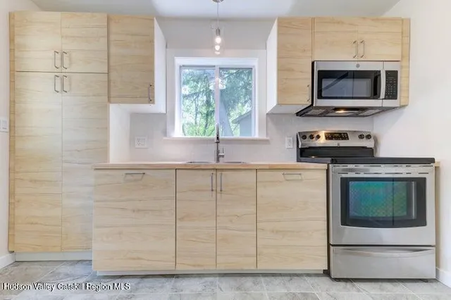 a kitchen with stainless steel appliances white cabinets and a stove top oven
