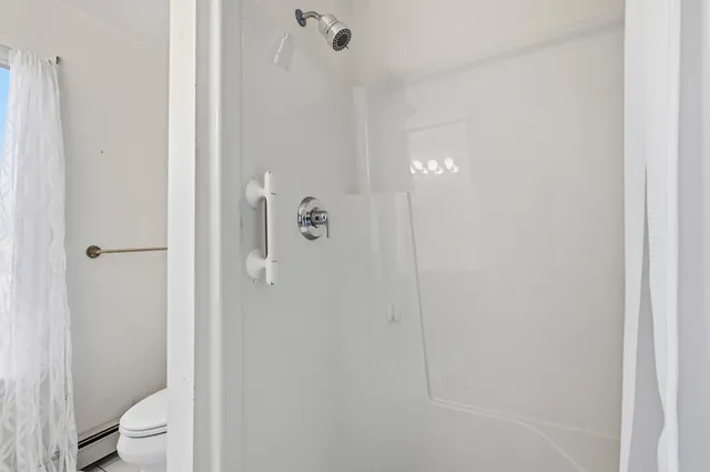 a bathroom with a toilet and a shower