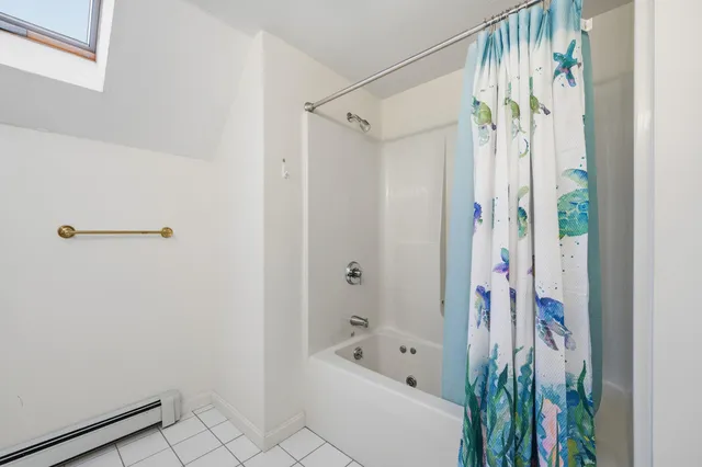 a bathroom with a bathtub a shower and a shower