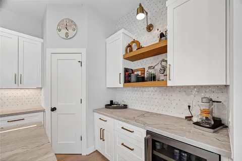 a kitchen with granite countertop a refrigerator a stove a kitchen island a dining table and chairs