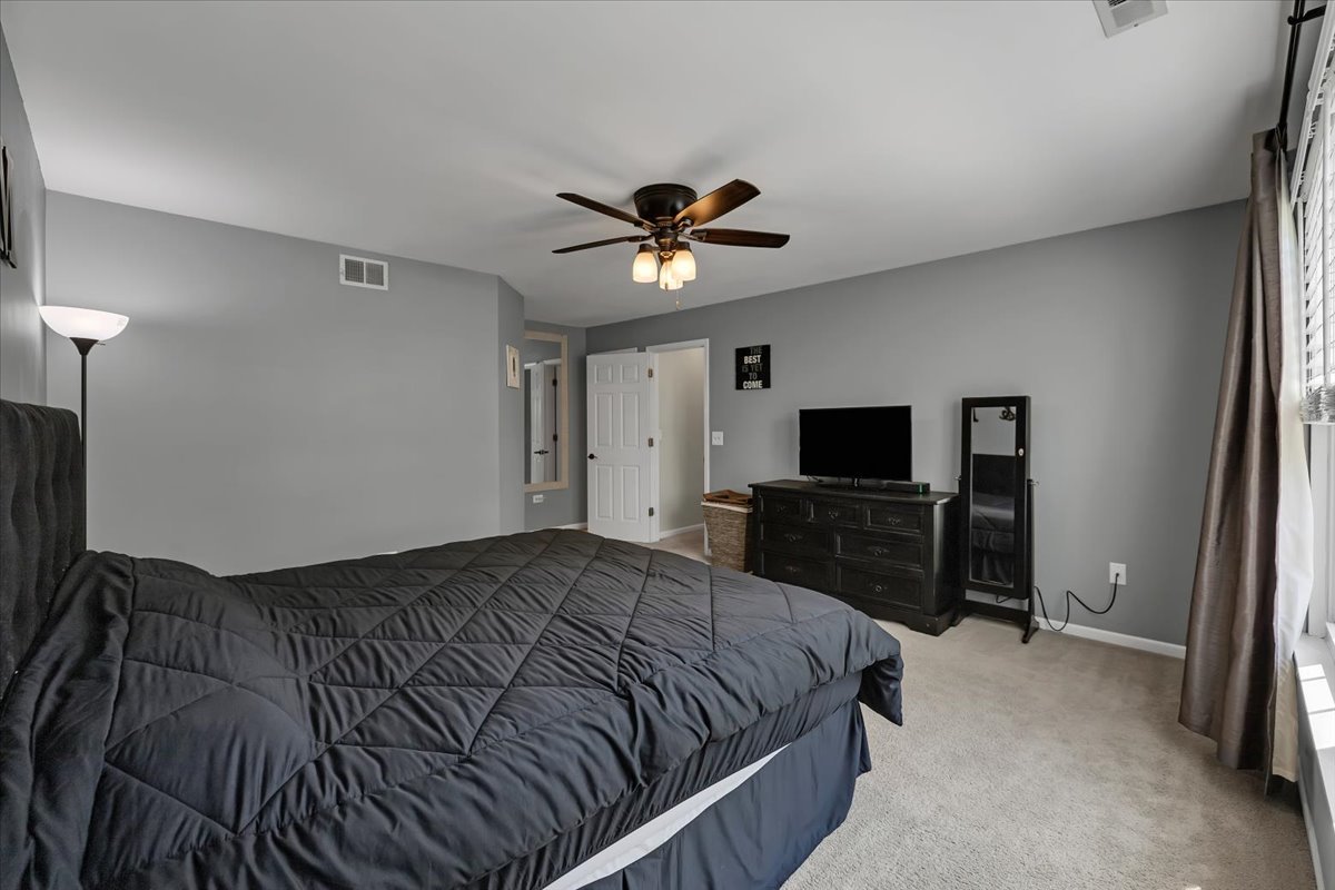2070 Constitution Court Elgin, IL 60123 - Photo 17 of 29 a bedroom with a bed and a flat screen tv