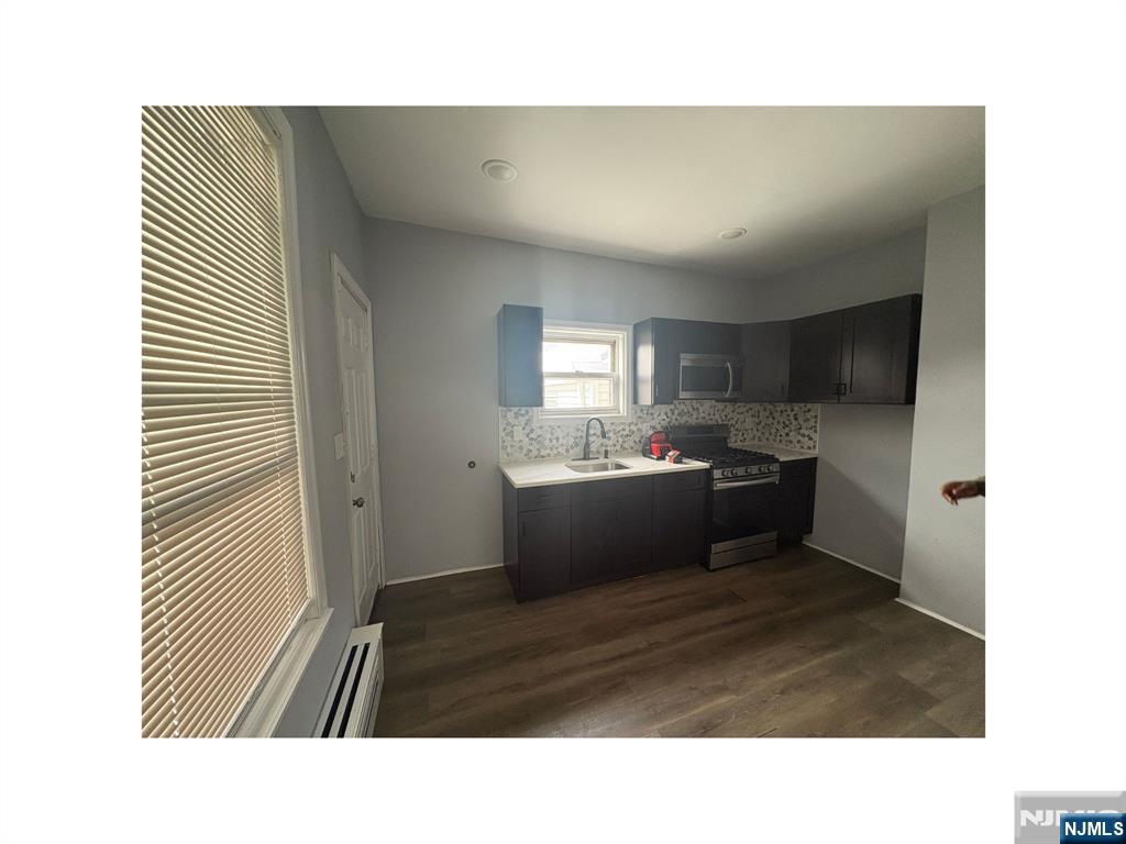 93 Highland Street, Unit 2 Paterson, NJ 07524 - Photo 3 of 9 a kitchen with a refrigerator and a sink