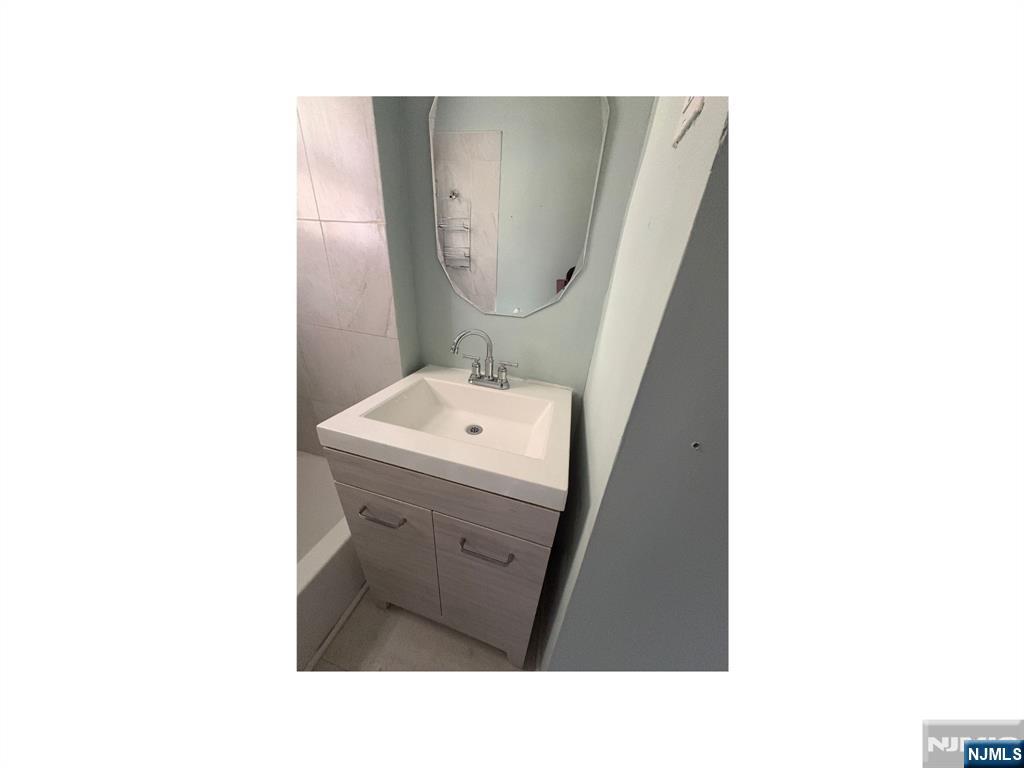 93 Highland Street, Unit 2 Paterson, NJ 07524 - Photo 9 of 9 a bathroom with a sink and mirror