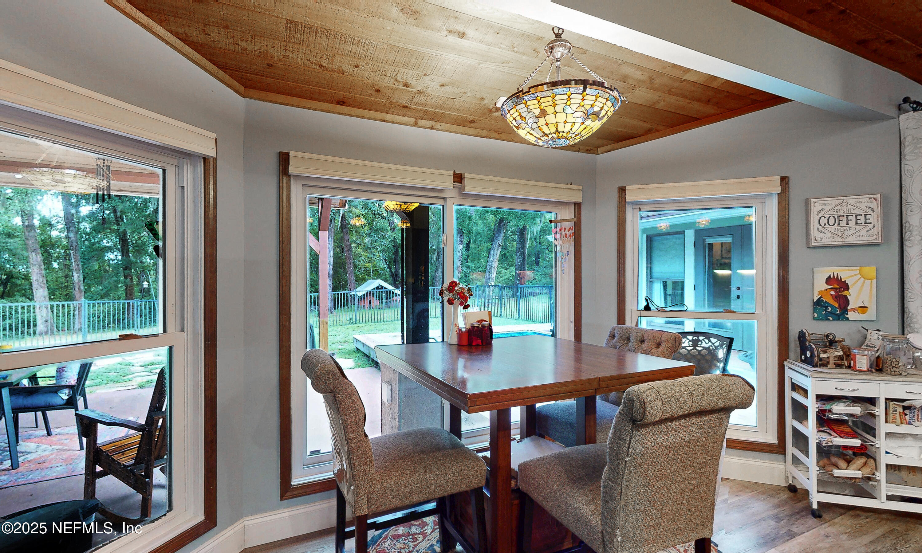 2860 Ravines Road Middleburg, FL 32068 - Photo 14 of 52 a view of a dining room with furniture large windows outdoor and garden view