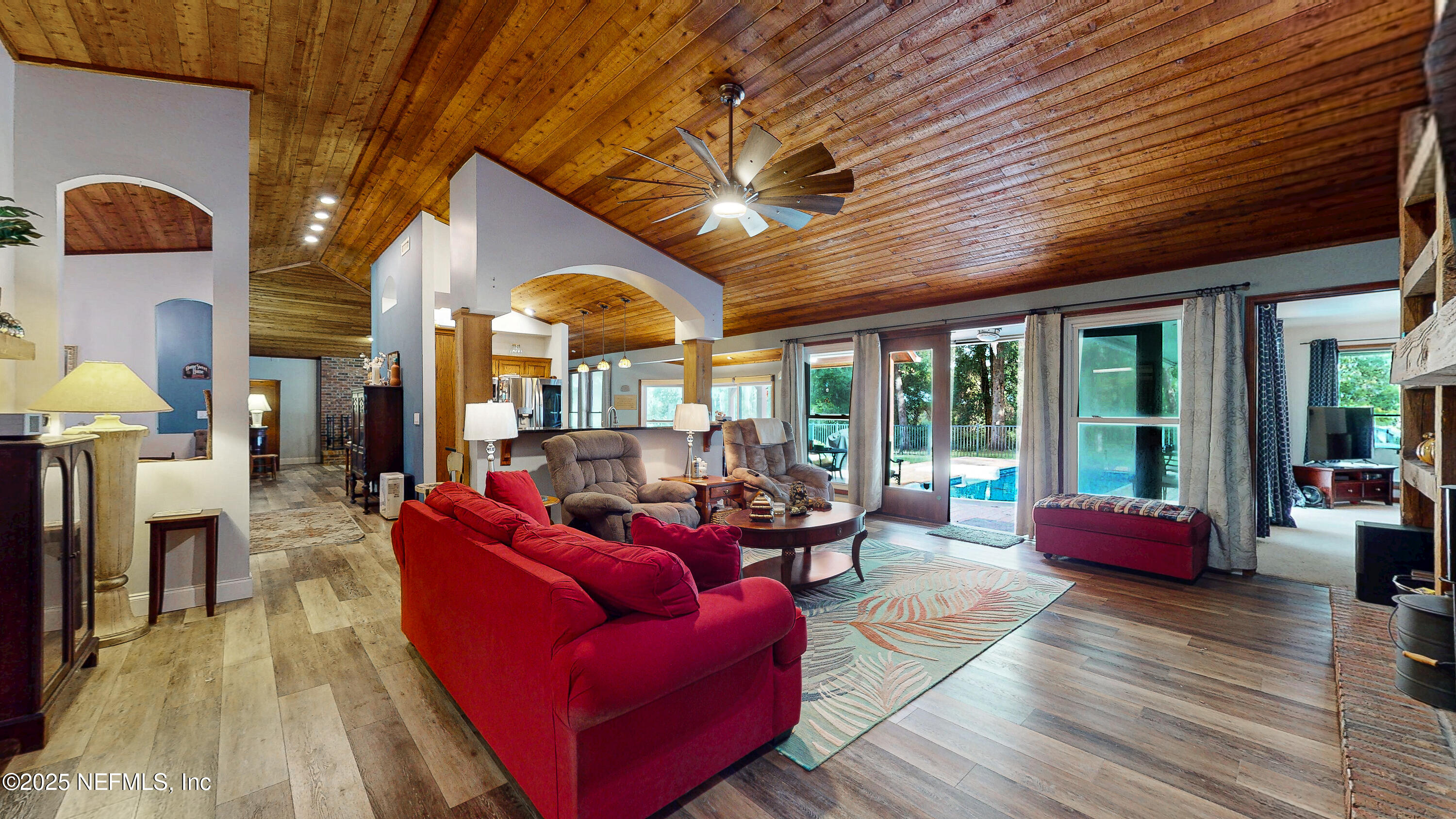 2860 Ravines Road Middleburg, FL 32068 - Photo 16 of 52 a living room with furniture a fireplace wooden floor and a large window