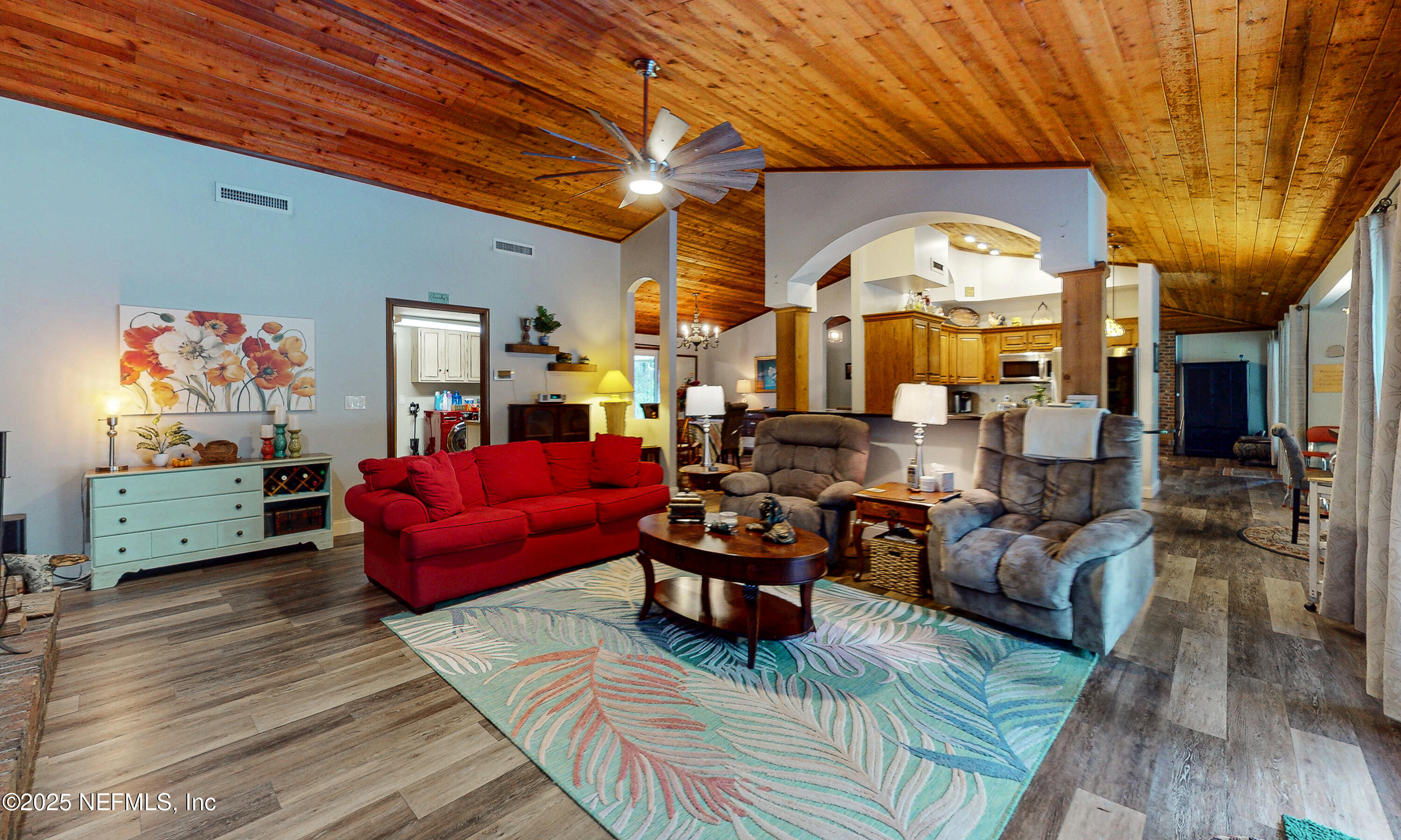 2860 Ravines Road Middleburg, FL 32068 - Photo 17 of 52 a living room with furniture a large window and wooden floor