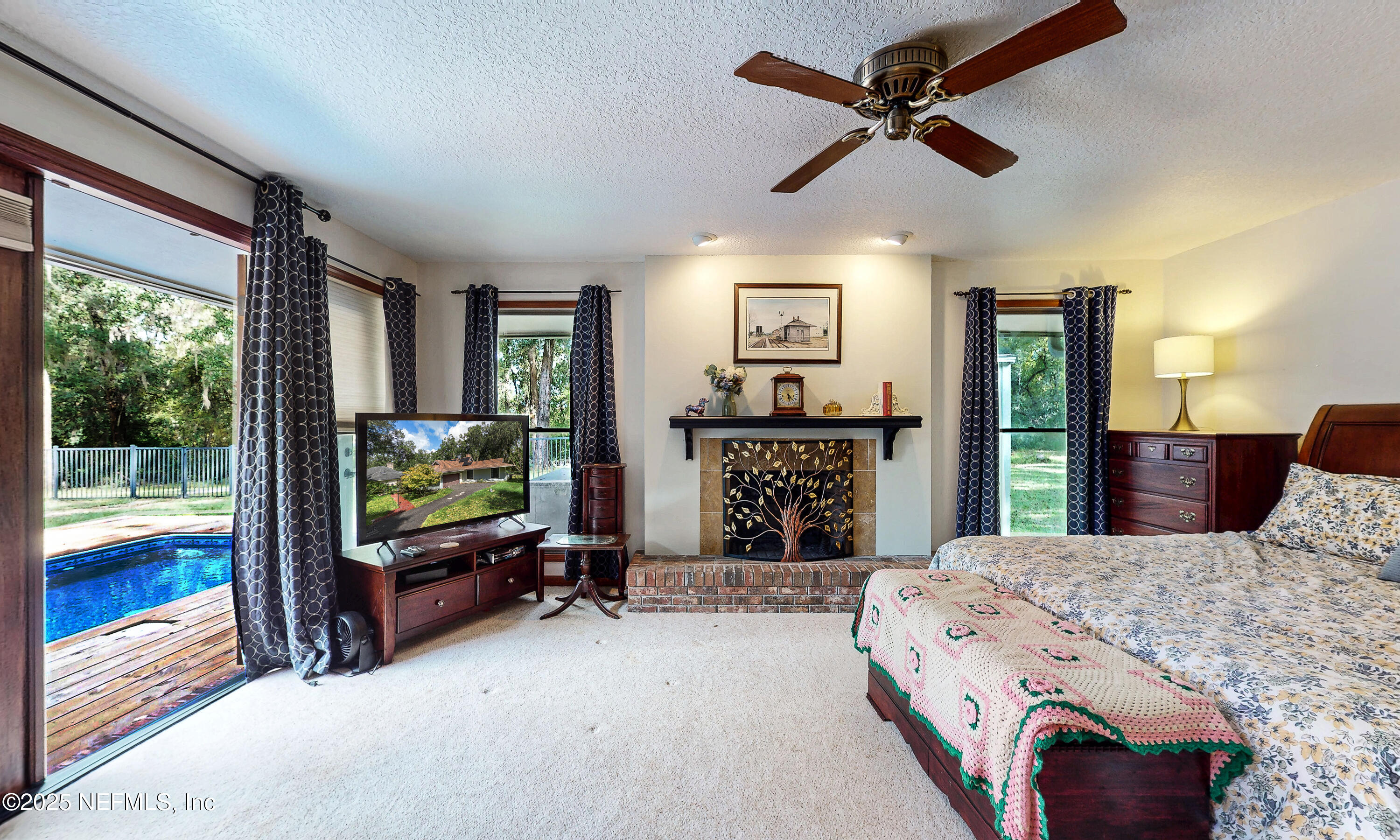 2860 Ravines Road Middleburg, FL 32068 - Photo 18 of 52 a bedroom with a bed dresser and a flat tv screen