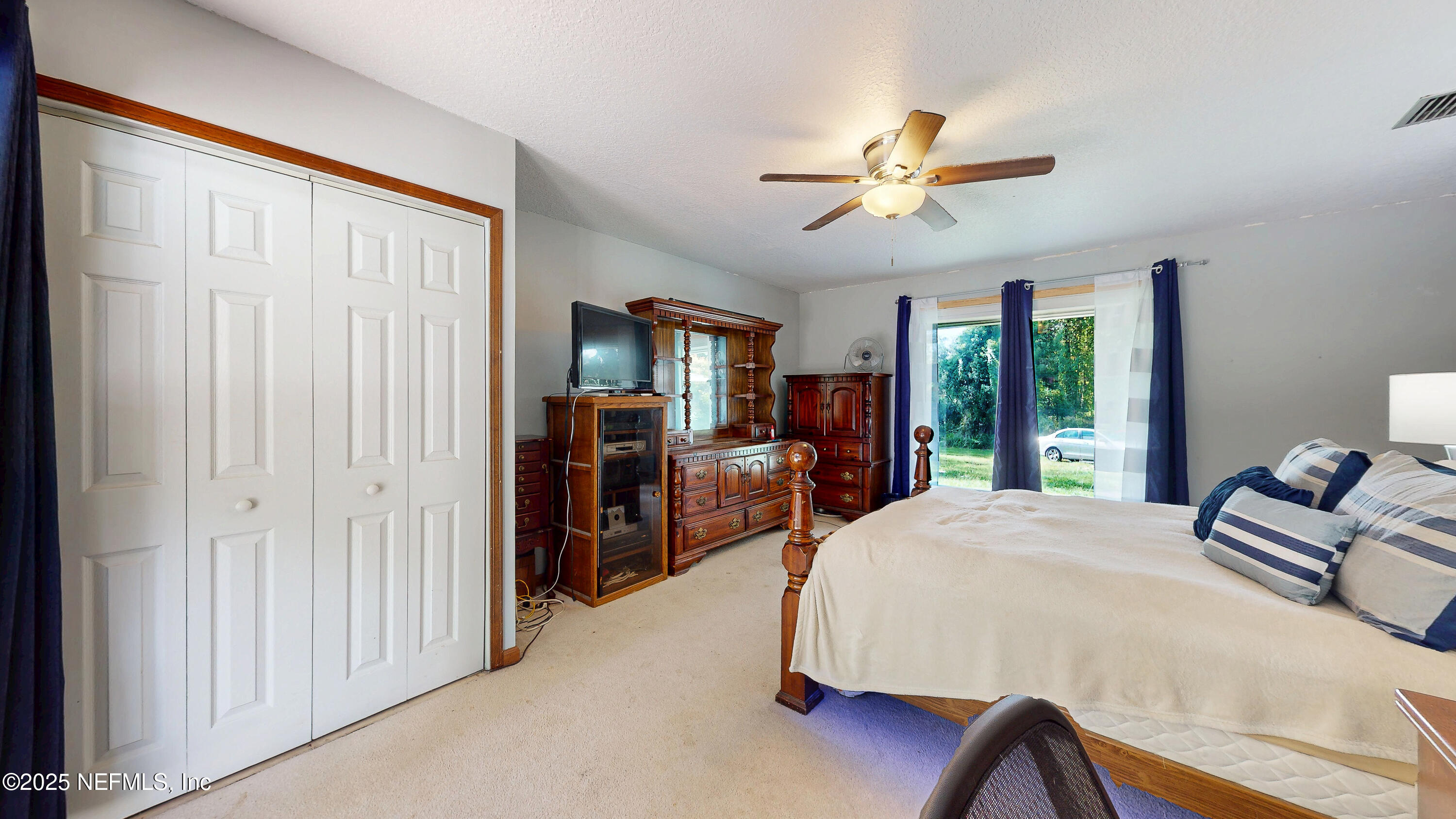 2860 Ravines Road Middleburg, FL 32068 - Photo 25 of 52 a bedroom with a bed and large windows
