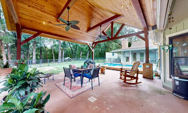 a view of a patio with a table and chairs under an umbrella